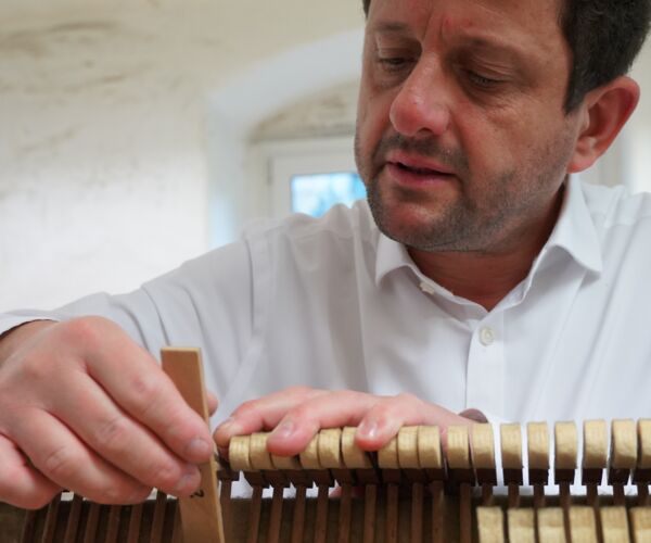 Stefan Weber beim Abziehen der Hammerköpfe mit einer kleinen Feile in der rechten Hand