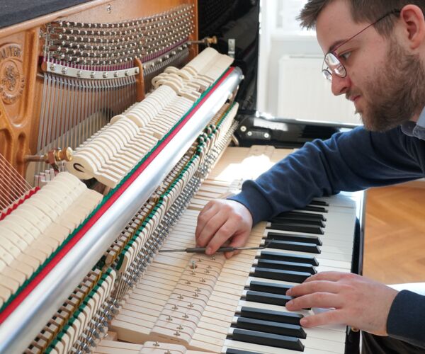 Sebastian Weber mit geschultem Auge, Fingerspitzengefühl und viel Erfahrung  beim Regulieren eines Klaviers